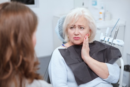 woman holding her face in pain